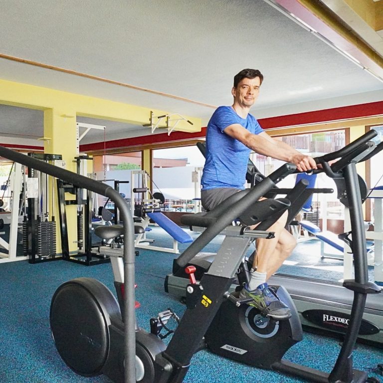 Fitnesscenter Ferienressort Kurhotel Schluchsee Mann trainiert an einem Fitnessgerät in einem modernen Fitnessstudio.