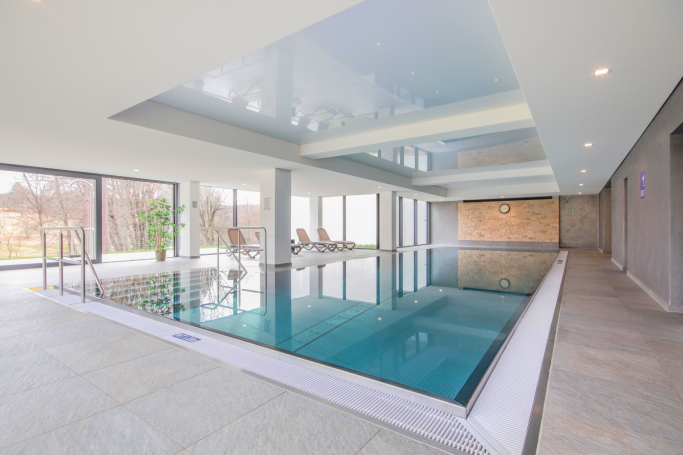 Innenpool mit großflächigen Fenstern und modernem, hellem Design.