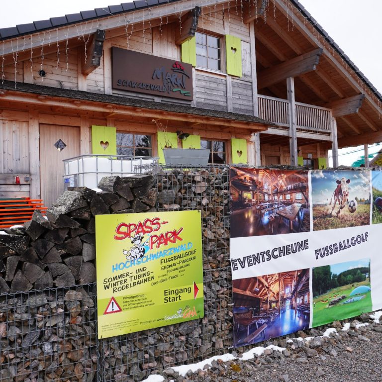 Holzhütte mit bunten Plakaten und Hinweisen zu Freizeitaktivitäten und Veranstaltungen.