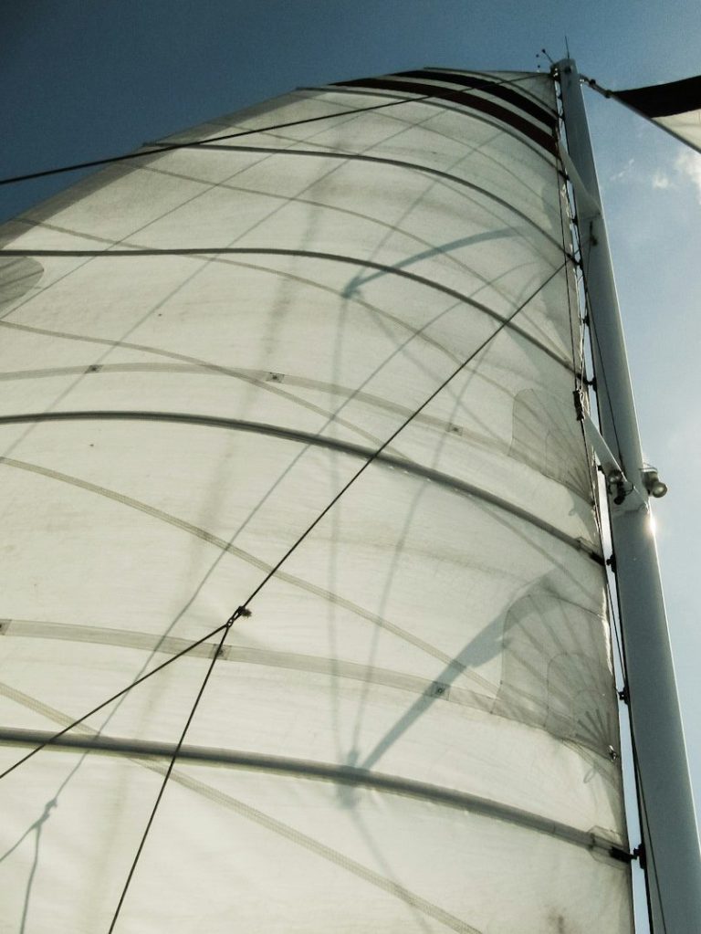 Nahaufnahme eines Segels, das mit einem Mast und Seilen verbunden ist.