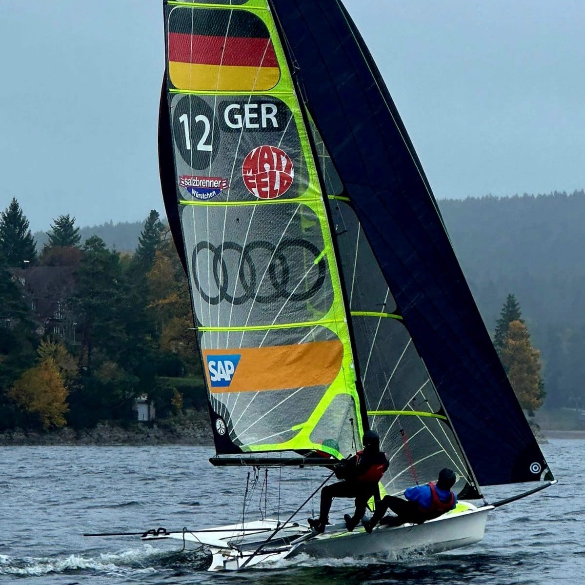 Copyright: Segelschule Schluchsee, Thomas Nagel Segelboot mit deutscher Flagge auf dem Schluchsee, Segler in Aktion.