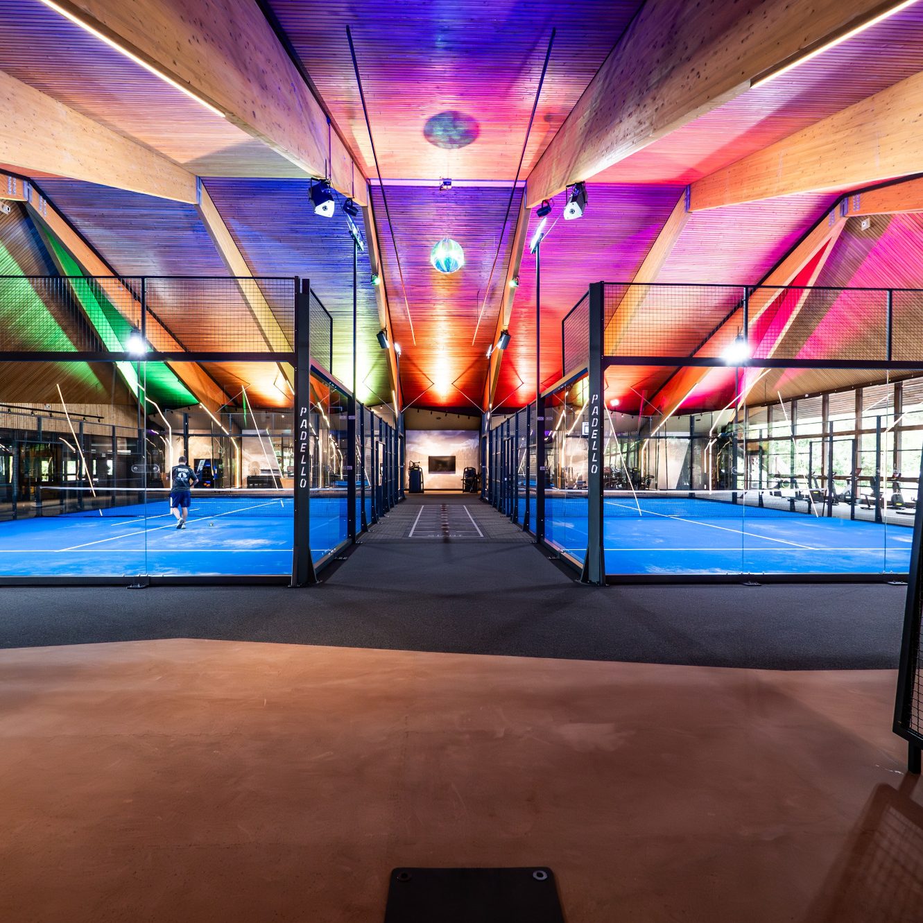 Moderne Sporthalle mit bunten Beleuchtungen und Padel-Court.