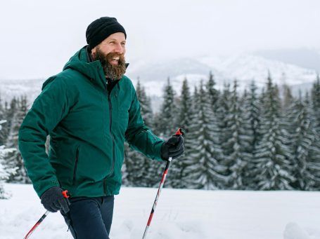 Loipenzugang Schluchsee Informationstafel in einer schneebedeckten Landschaft mit Nebel im Hintergrund.